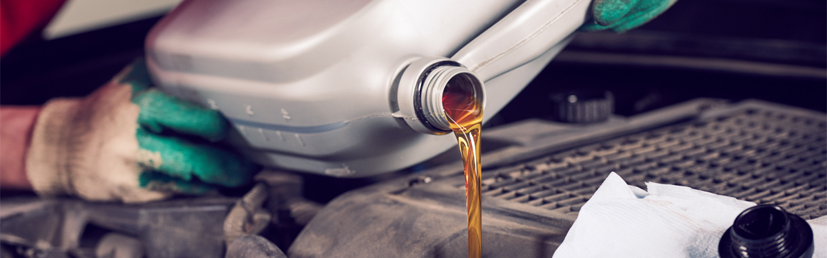 Mechanic pouring engine oil into a vehicle