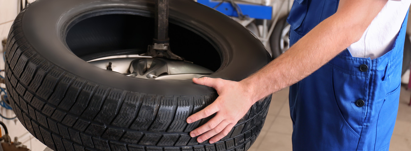 Mechanic holding a Car Tyre